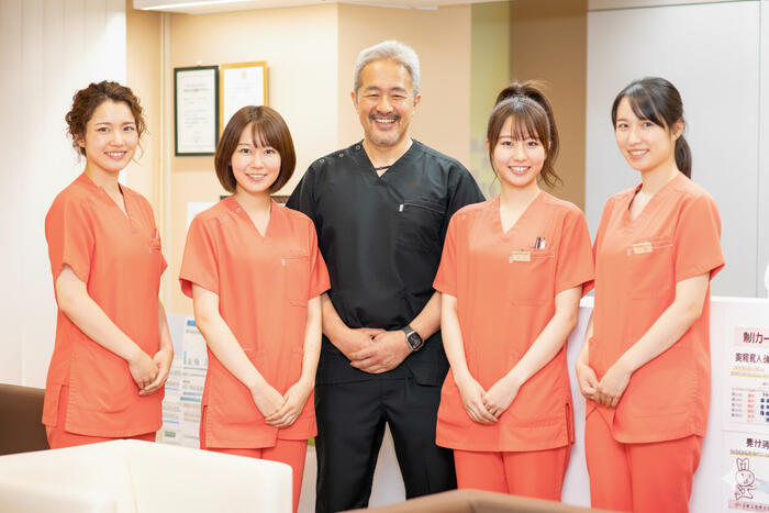 Gi外科クリニックの医師とスタッフが笑顔で並ぶ集合写真